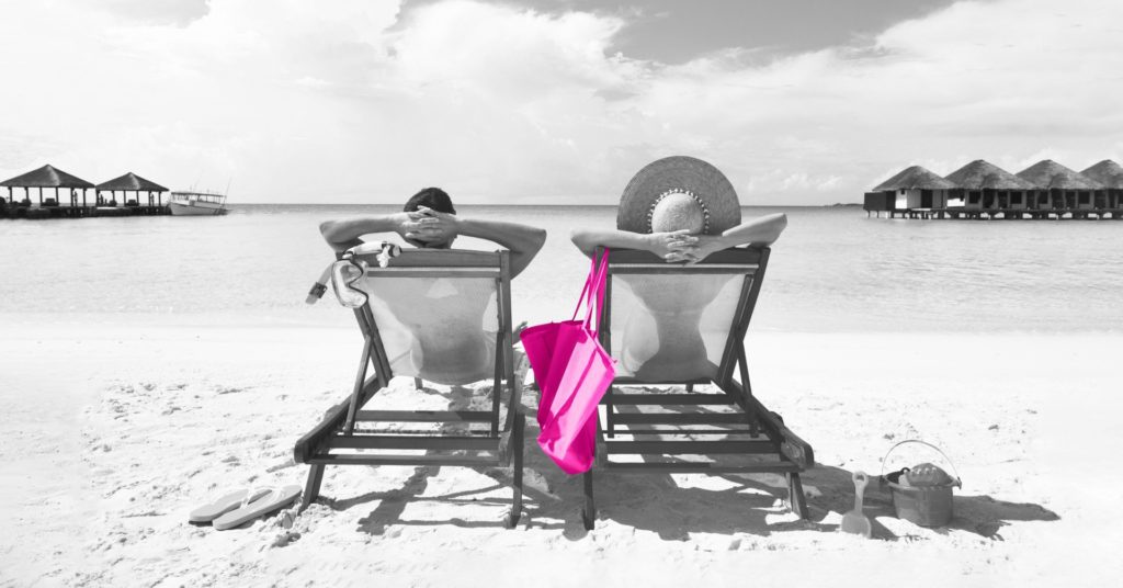 Couple relaxing in deck chairs on the beach