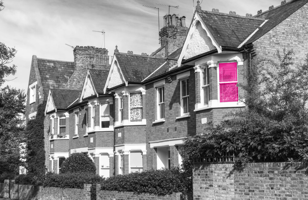 a row of terraced houses with one window coloured pink