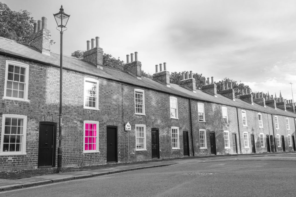 Image shows a row of Victorian terraced houses along a town road. There is a lamppost outside the first house on the row
