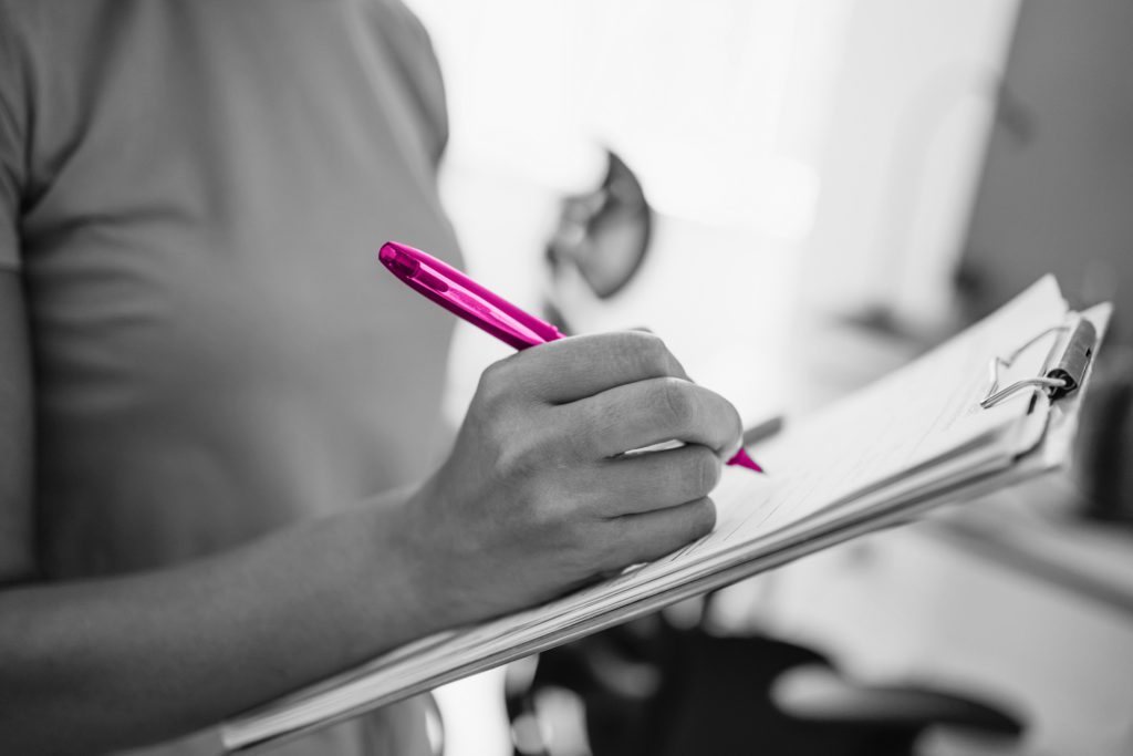 woman writing on a clipboard